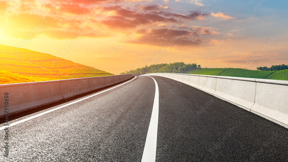 Naklejka premium Asphalt road and mountain with tea plantation at sunset.Road and mountain background.