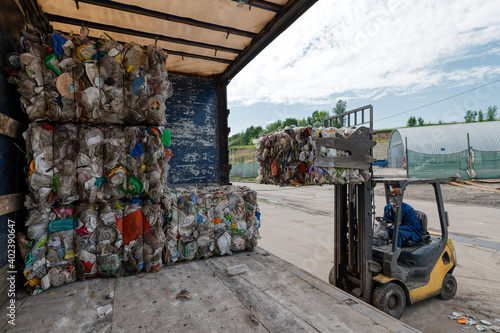 Cuadro en lienzo A forklift loads bales of compressed plastic bottles into a truck trailer