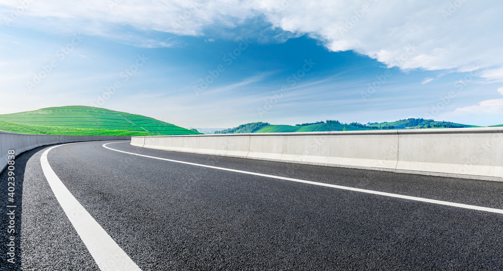 Asphalt road and mountain with tea plantation under blue sky.Road and mountain background. Asphalt road and mountain with tea plantation under blue sky.Road and mountain background.