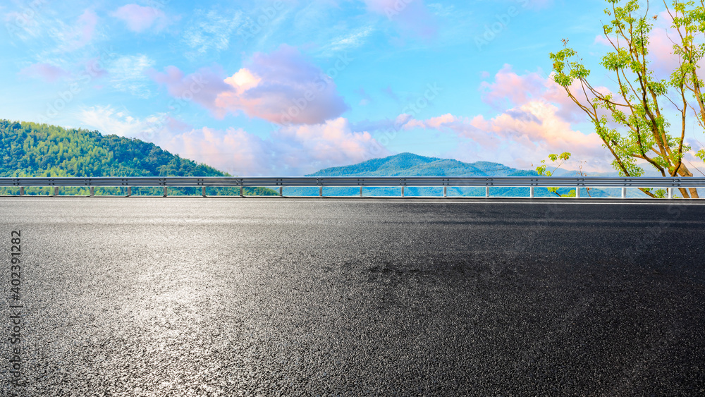Fototapeta premium Asphalt road and mountain at sunset.Road and mountain background.
