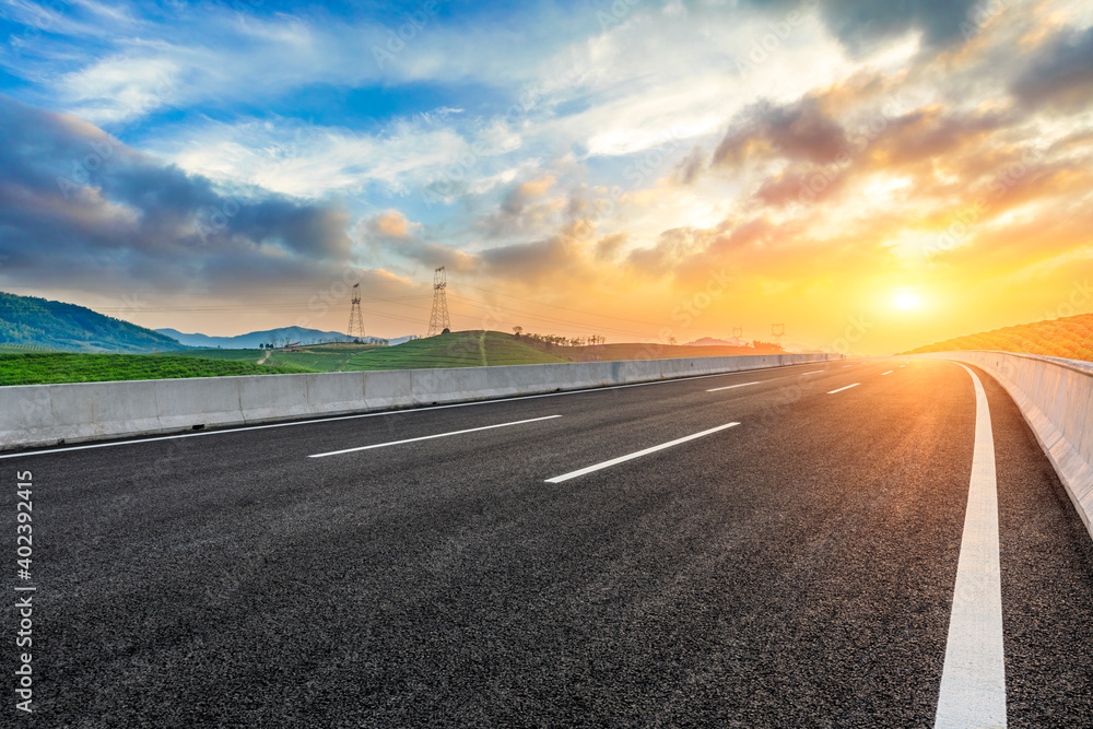 Fototapeta premium Asphalt road and mountain at sunset.Road and mountain background.