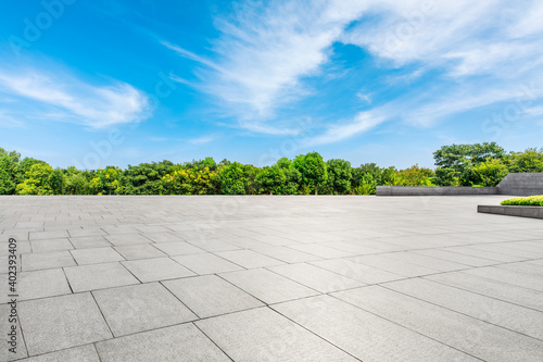 Empty square floor and green forest background.
