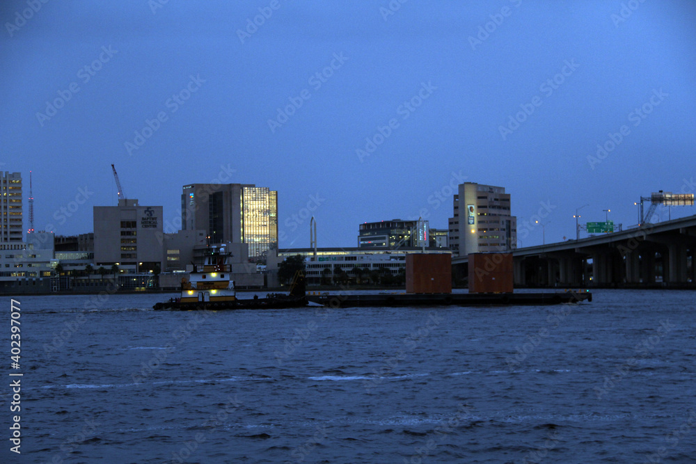 Naklejka premium Barge moves cargo at night