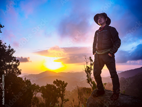Traveler man enjoying serenity view of mountains at sunrise.
