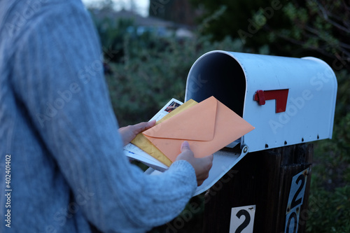 Fotografiet woman collect mails from a mailbox