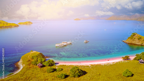 Aerial view of a Pink beach in Flores, with a tourist and a yatch