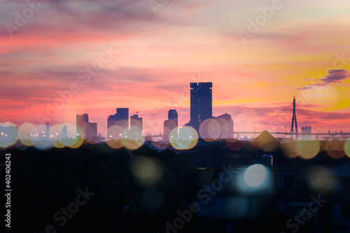 Orange morning sky sunrise over city skyscraper view with bokeh light  skyline horizon cityscape and urban architecture  buildings at dawn