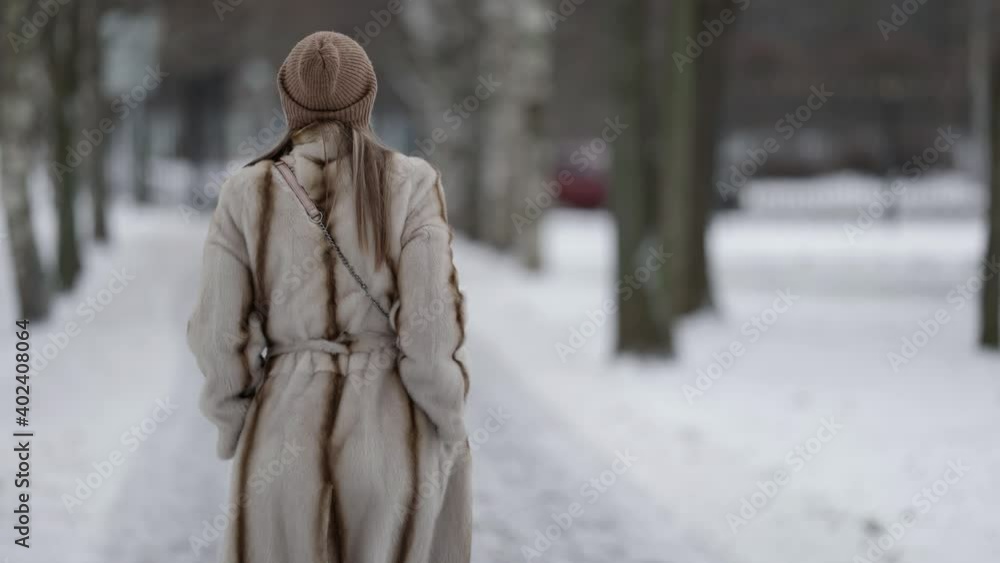 happy lady dressed fur coat is enjoying walk in winter park, strolling over snowy path happy lady dressed fur coat is enjoying walk in winter park, strolling over snowy path