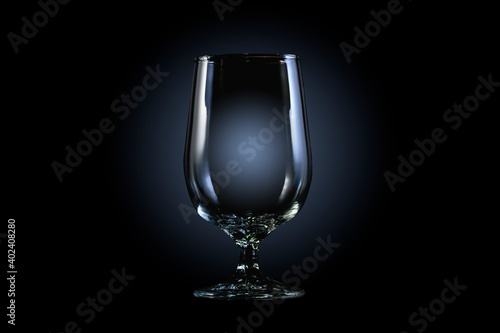 Empty glass for whiskey, brandy or bourbon on a black background with copy space. 