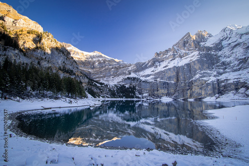 Dans les alpes suisses, photos d'un lac de montagnes avec la neige et des reflets.