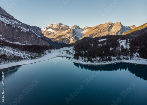 Dans les alpes suisses, photos d'un lac de montagnes avec la neige et des reflets.
