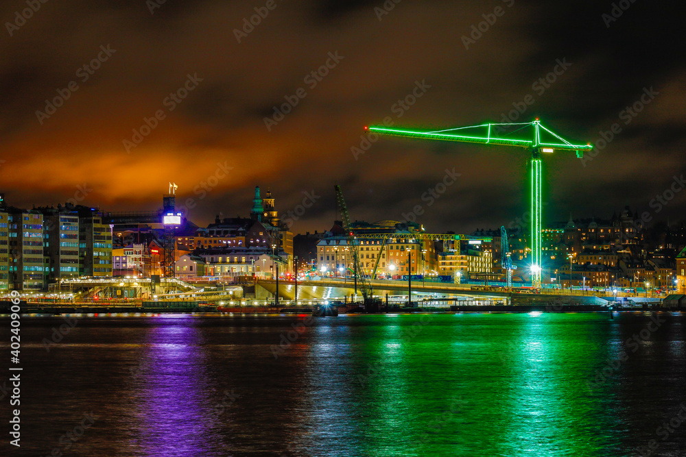 Stockholm, Sweden A large building crane lit in green lights at Slussen.
