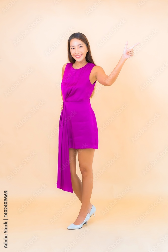 Portrait beautiful young asian woman in action on color background Portrait beautiful young asian woman in action on color background