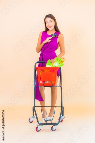 Portrait beautiful young asian woman with grocert basket from supermarket