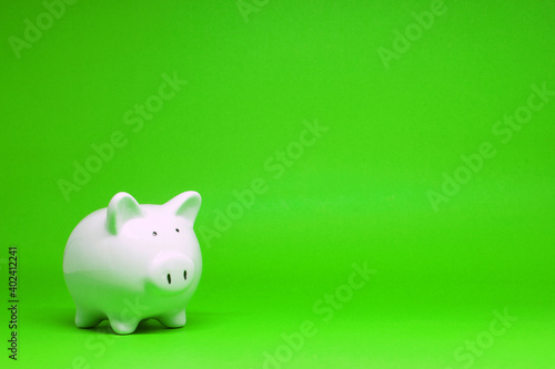White Piggy bank on green background with copy space for text message - Fund , Investment , Saving money - green concept of Banking and Stable financial