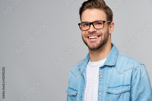 Portrait of young handsome caucasian man in jeans shirt over light background