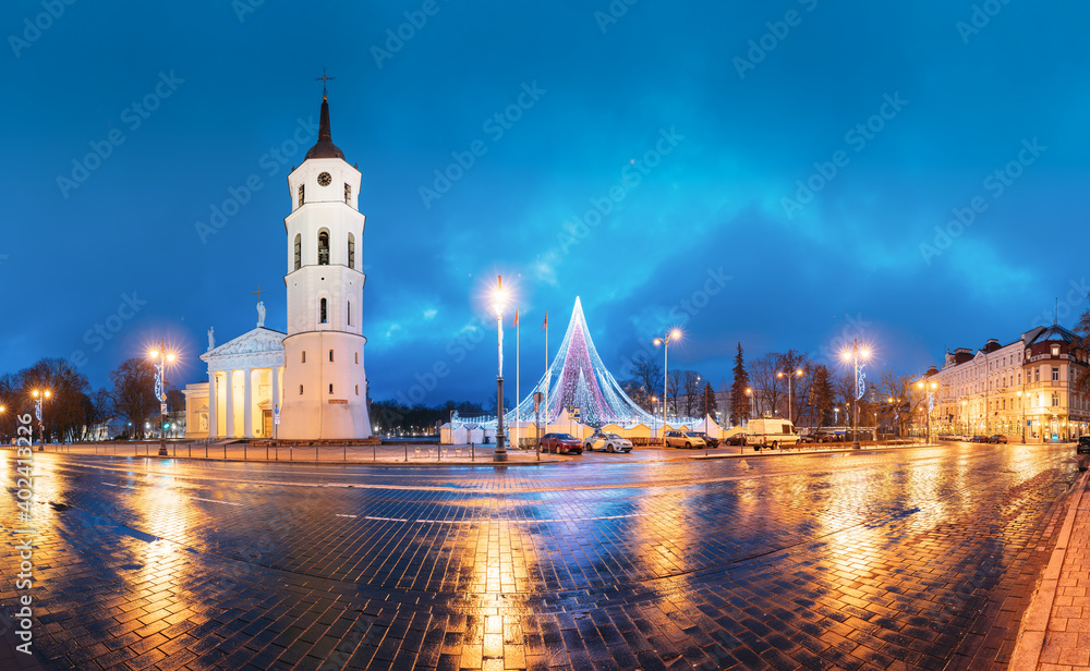 Fototapeta premium Vilnius, Lithuania. Christmas Tree On Background Bell Tower Belfry Of Vilnius Cathedral At Cathedral Square In Evening New Year Christmas Xmas Illuminations. Unesco World Heritage Site