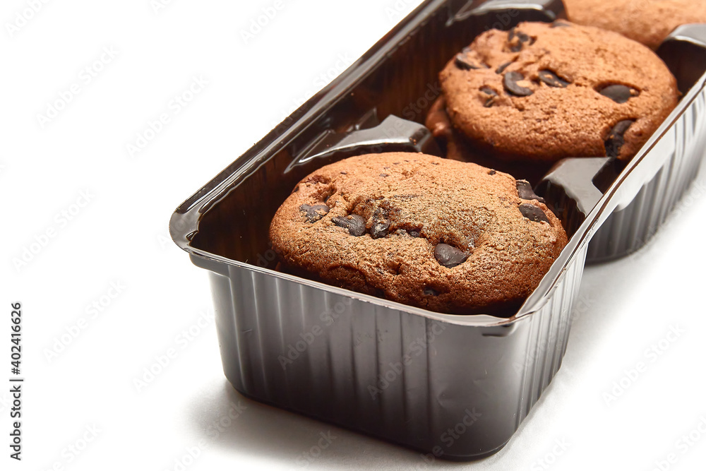 Delicious cookies with cocoa powder and droplets of chocolate icing in packaging on a white background. Delicious cookies with cocoa powder and droplets of chocolate icing in packaging on a white background.