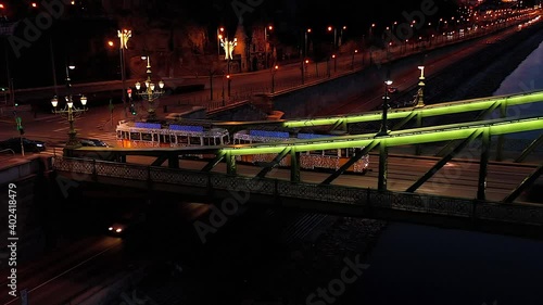 4k Video about the christmas light decorated tram in the Liberty bridge Budapest, Hungary. This tram works only christmas time every year. Amazing tourist attraction.  photo