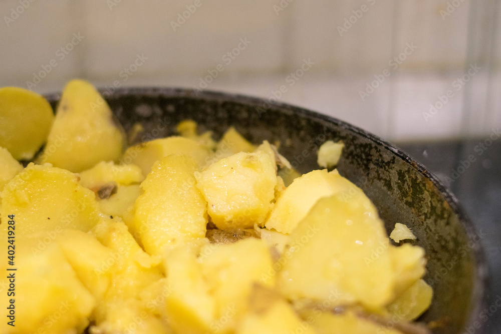 Fried potatoes. Cast-iron pan. Wooden spatula. Homemade food. Fried potatoes. Cast-iron pan. Wooden spatula. Homemade food.