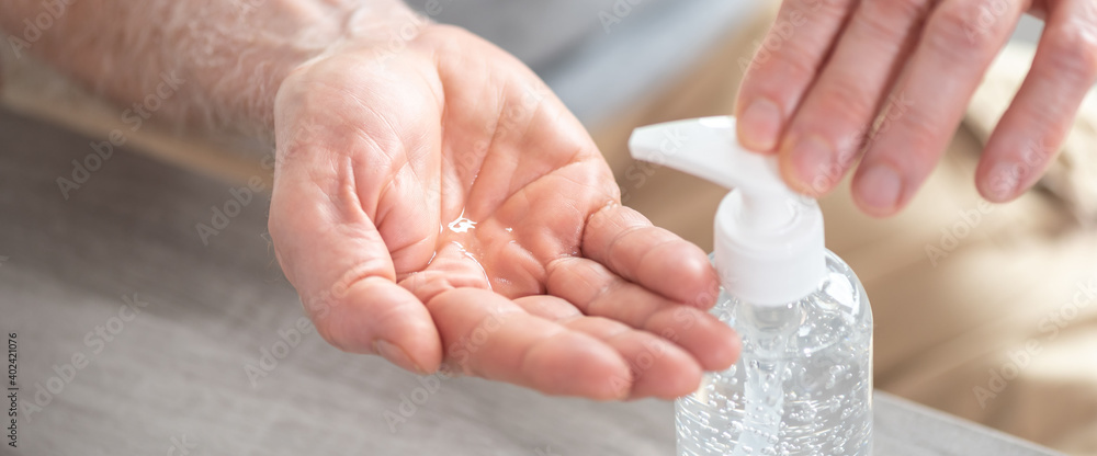 Hand pressing on sanitizer bottle; prevention of virus and bacteria infection Hand pressing on sanitizer bottle; prevention of virus and bacteria infection