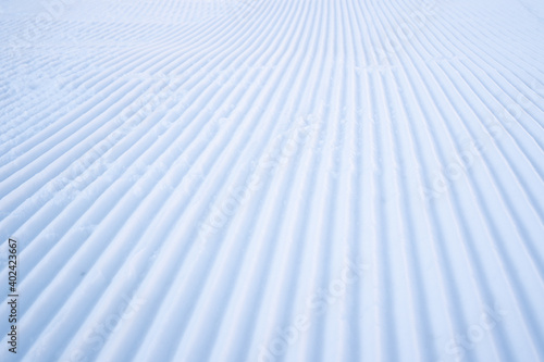 Velvet snow. Fresh snow groomer tracks on a mountain ski piste. Newly groomed snow on ski slope