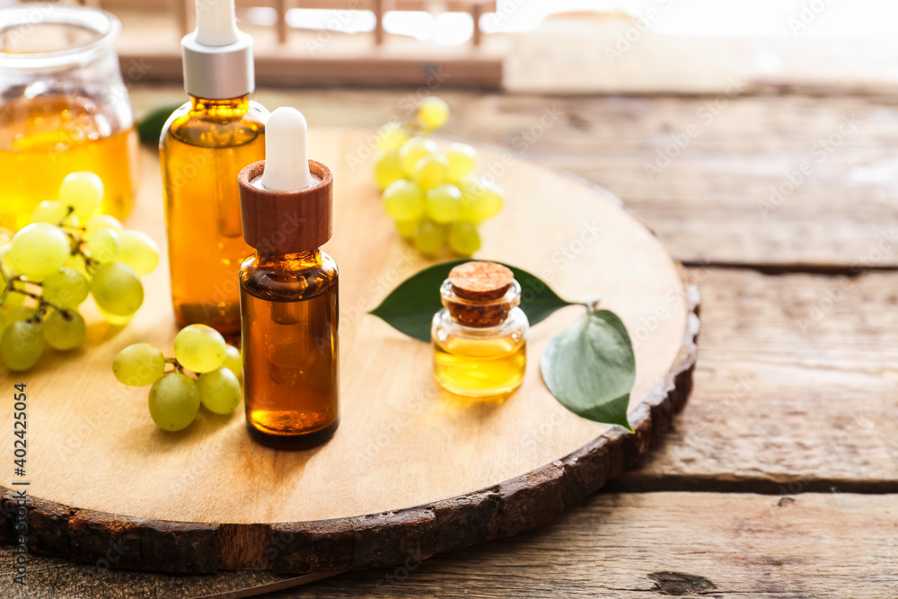 Bottles with grape seed oil on wooden board Bottles with grape seed oil on wooden board