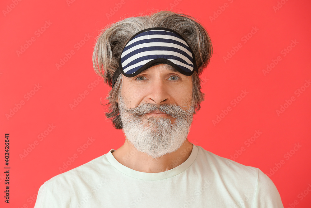 Mature man in sleep mask on color background Mature man in sleep mask on color background