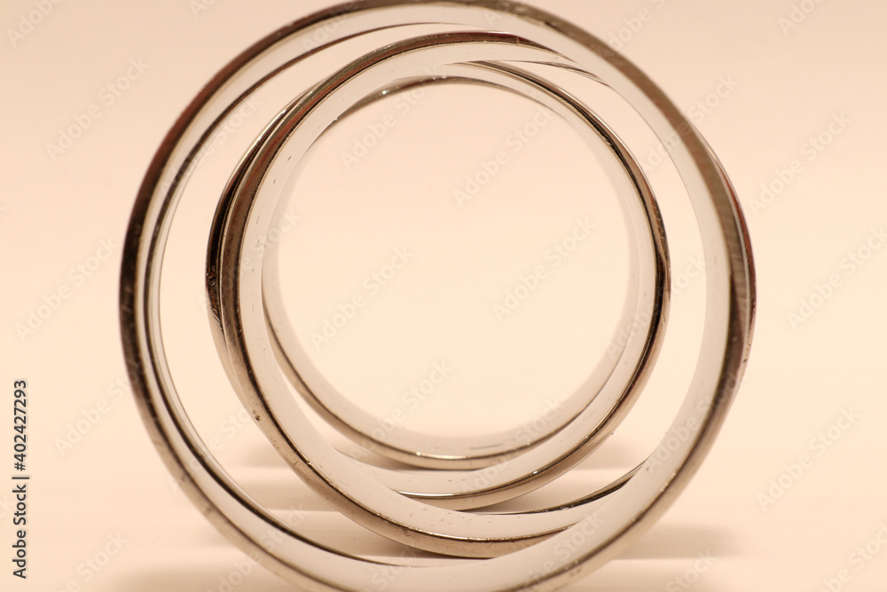 Silver rings in formation. Shiny metal and design art. Metallic objects. Close up and isolated on a white background. Stockholm, Sweden. Silver rings in formation. Shiny metal and design art. Metallic objects. Close up and isolated on a white background. Stockholm, Sweden.