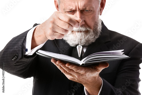 Wallpaper Mural Male fortune teller with pendulum and book on white background Torontodigital.ca