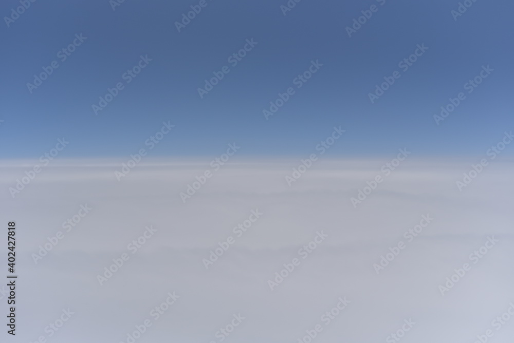 view of sky from airplane which flying over clouds in troposphere