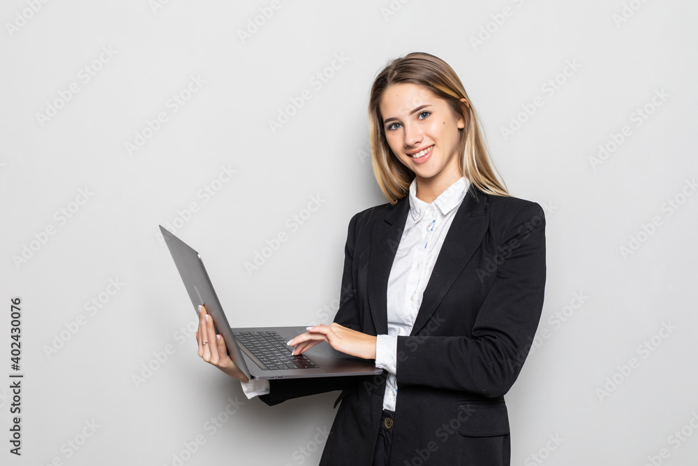 Successful business woman is standing with laptop on white isolated background. Successful business woman is standing with laptop on white isolated background.
