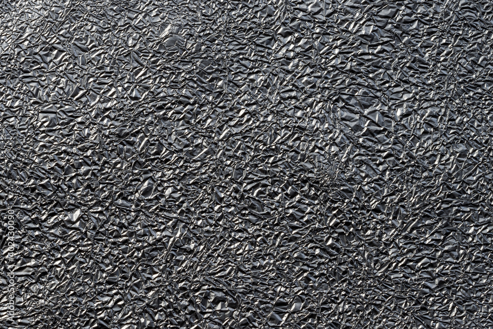 Winkled aluminium foil for desktop background. Shiny silver metalized texture close up Winkled aluminium foil for desktop background. Shiny silver metalized texture close up