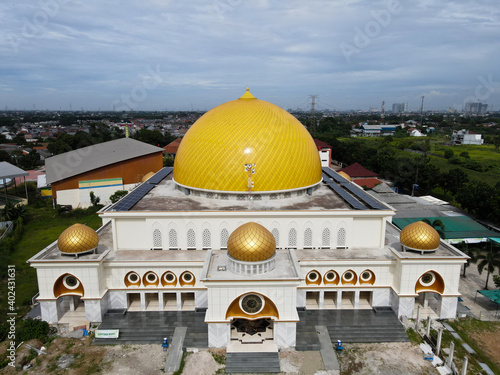 Aerial view of The Largest Mosque Masjid Kubah Emas at Bekasi, Ramadan Eid Concept background, Travel and tourism. With noise cloud. photo