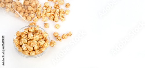 Caramel popcorn in a glass bowl with copy space on a white background