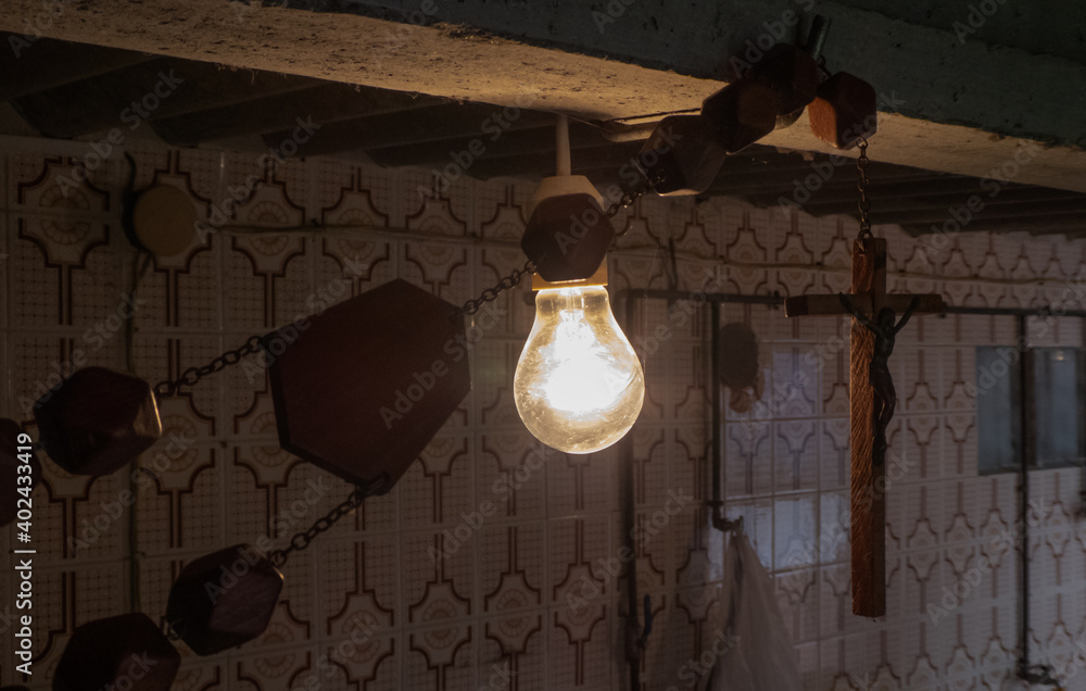 Dark shed with a light bulb on and a crucifix Dark shed with a light bulb on and a crucifix