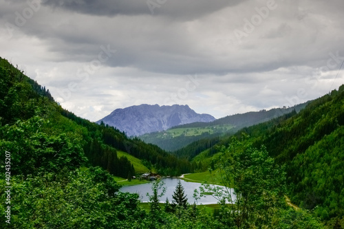 mountain lake in a green mountain landscape with view to a mountain