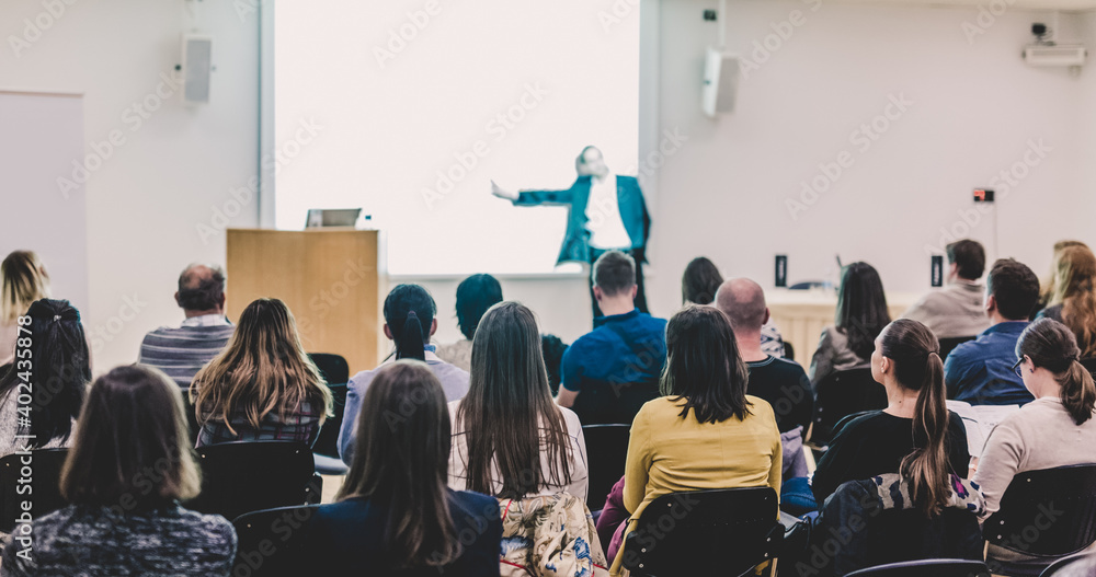 Speaker Giving a Talk at Business Meeting. Audience in the conference hall. Business and Entrepreneurship. Focus on unrecognizable people from rear. Speaker Giving a Talk at Business Meeting. Audience in the conference hall. Business and Entrepreneurship. Focus on unrecognizable people from rear.