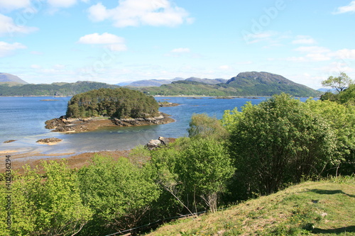 Beautiful scenic view over green hills, rocks and water in Scotland