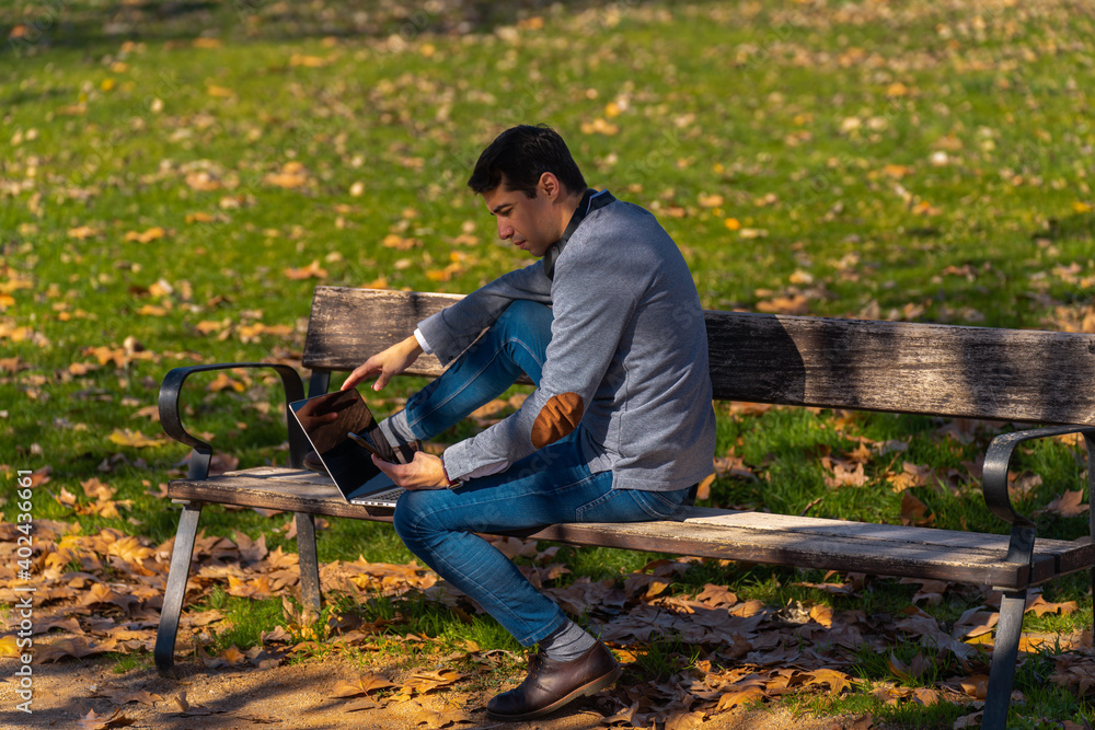 Man sitting in the park working with his laptop Man sitting in the park working with his laptop