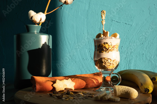 biscuits, bananas, yoghurt and muesli in a glass and muesli sprinkled a little on the table