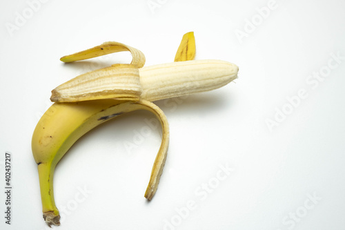 yellow, ripe and open banana lies on a white background