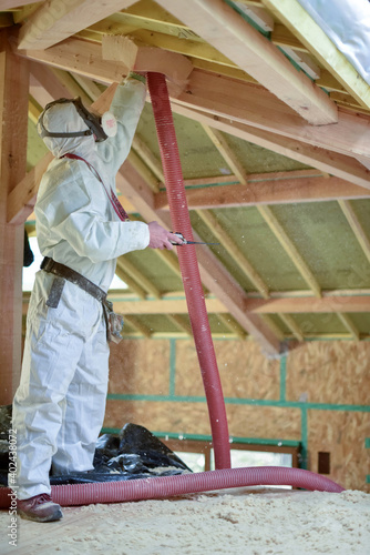 carpenter projecting insulation into a roof photo