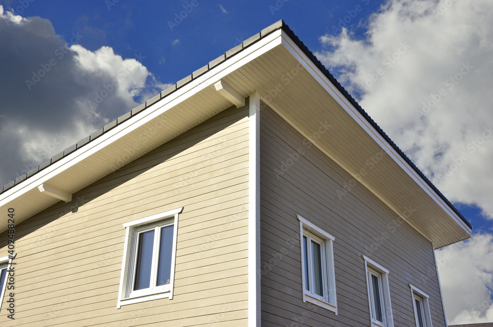 Neubau eines mit beschichteten Holzplanken verschalten Niedrigenergie-Einfamilienhauses in Holzständer-Bauweise mit immer häufiger verwendetem Pultdach mit Aufsparrendämmung