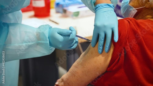 Patient is being vaccinated during COVID-19 vaccination program with the Pfizer BioNTech vaccine at the Medical University of Warsaw, Poland photo