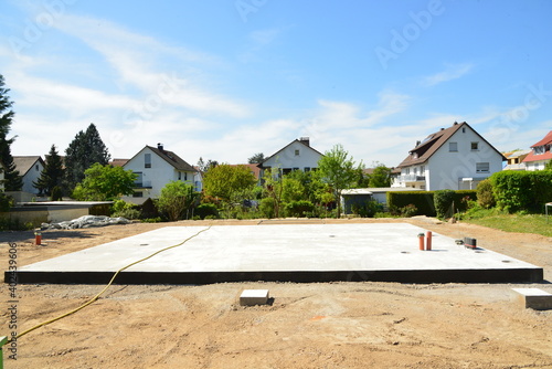 Frisch betonierte Bodenplatte für ein frei stehendes Einfamilienhaus in eienm Neubaugebiet © Hermann