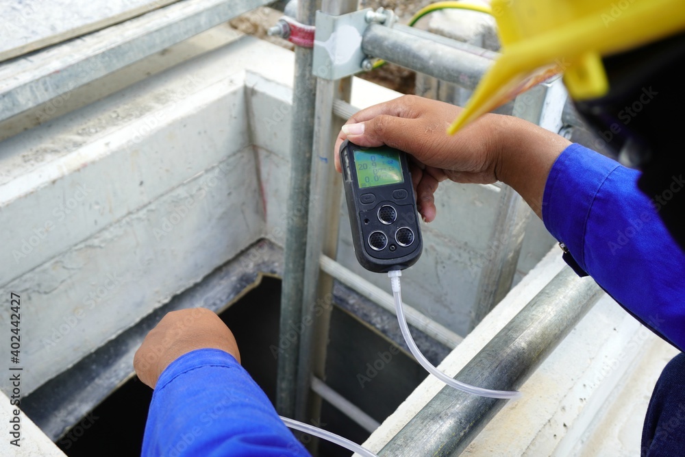 Construction supervisor hand holding gas detector device while