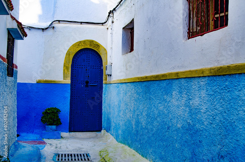 Nicely designed Alley with blue door and golden strip at Chefchaouen, Morocco © Naoufal