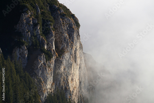 Mountain cliff surrounded by white clouds, Carpathian Mountains, Romania