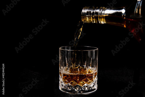 Whisky being poured into a cut glass tumbler
